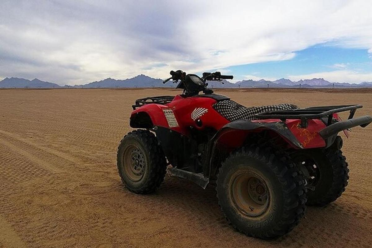 um quadriciclo vermelho no meio do deserto