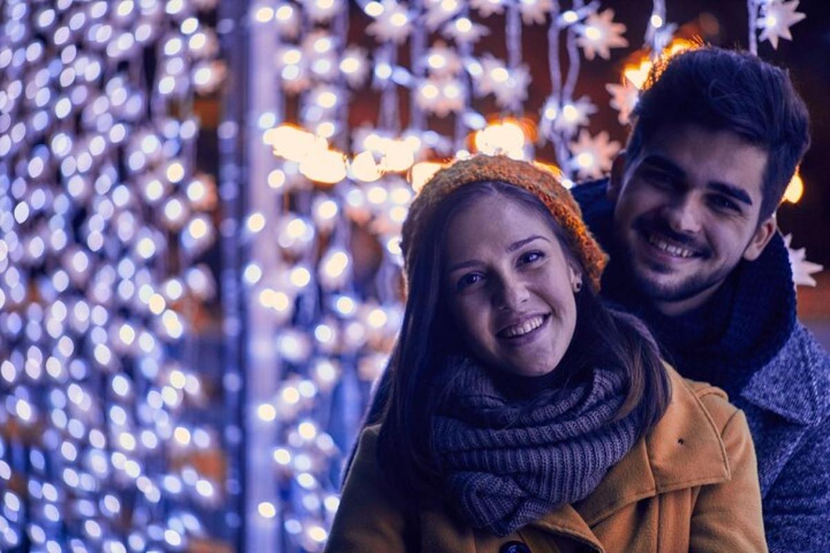 Maður og kona standa fyrir framan jólaseríur