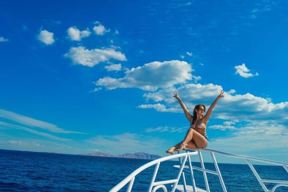 una donna in bikini seduta sul bordo di una barca