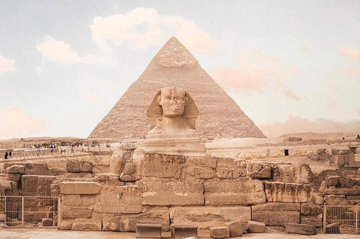 a pyramid and a statue in front of a pyramid