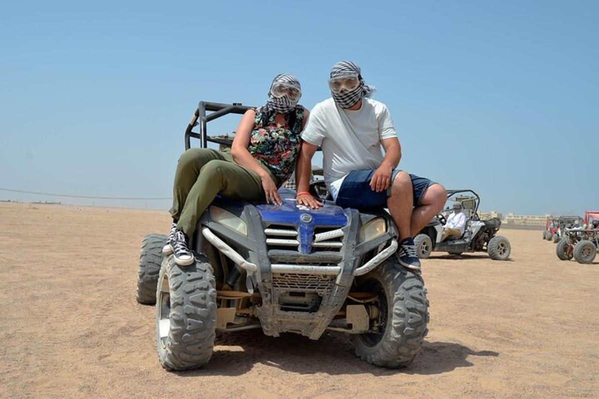 due persone sedute su un quad nel deserto