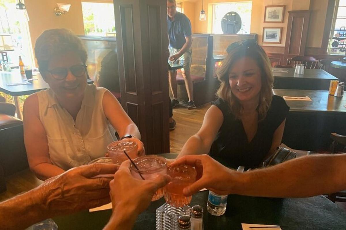 a group of people holding up glasses at a bar