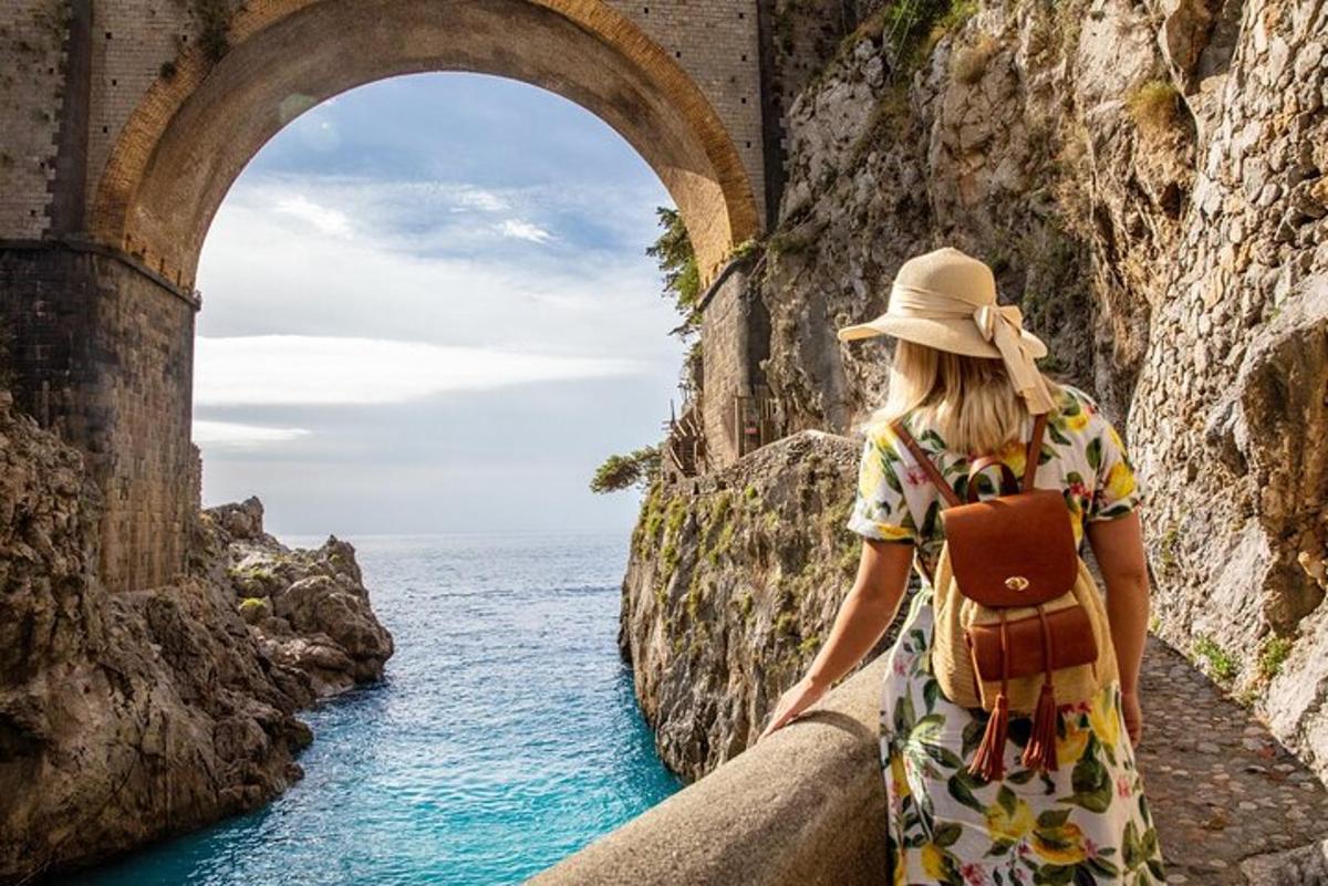 una donna in piedi su un ponte che guarda l'oceano