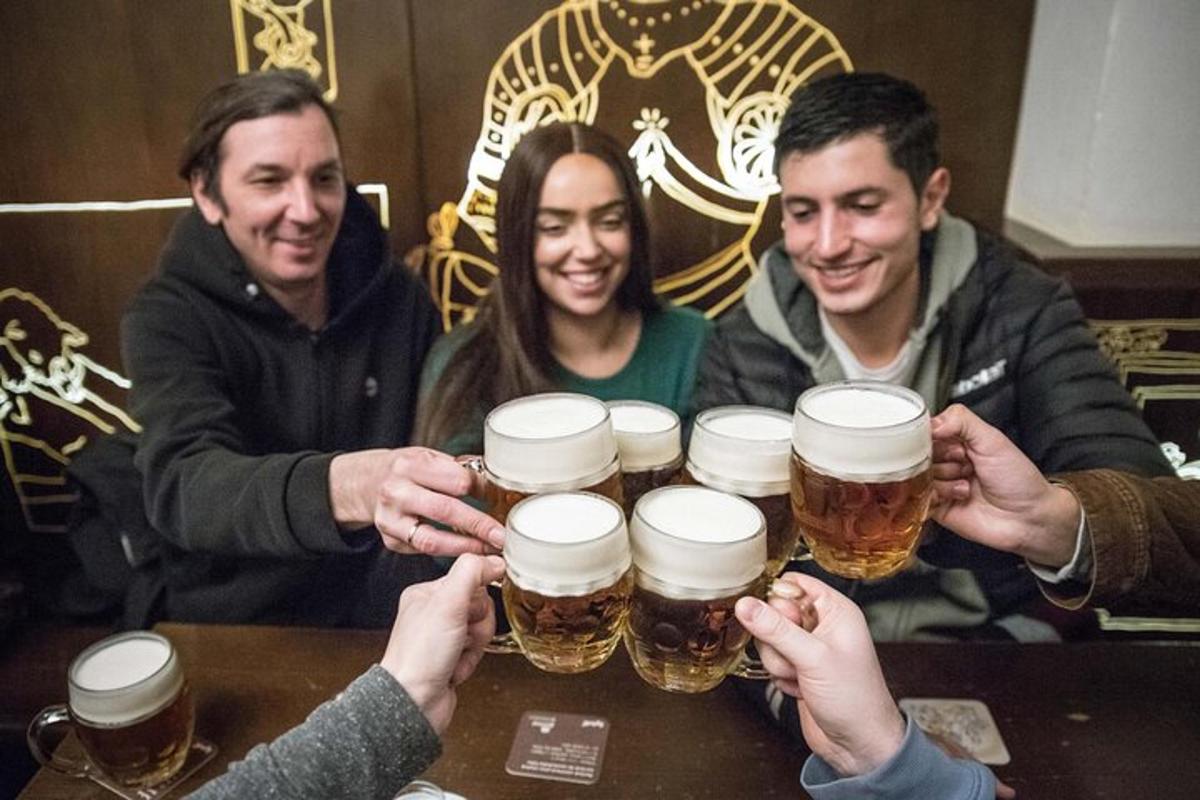 un grup de persones sostenint quatre gerres de cervesa