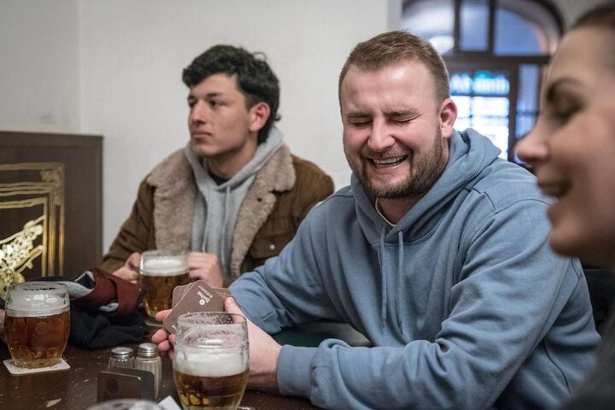un grup d'homes asseguts a una taula bevent cervesa