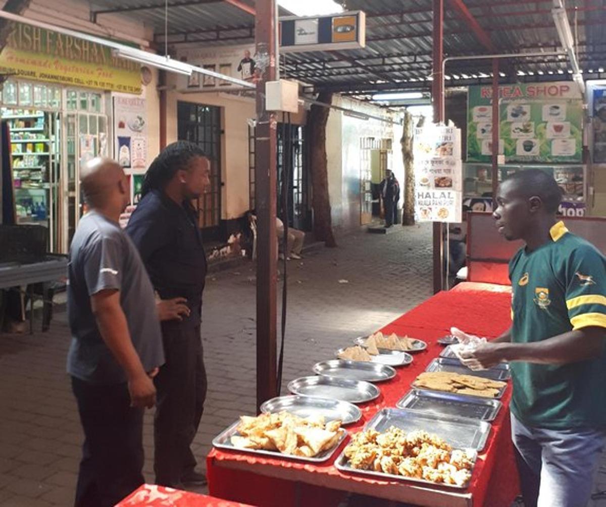 Un grupo de hombres de pie alrededor de una mesa con comida.