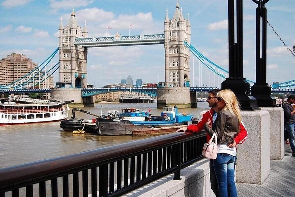 seorang wanita berdiri di jembatan dengan menara London