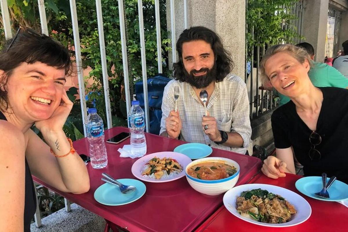 een groep mensen die aan een tafel zitten met eten