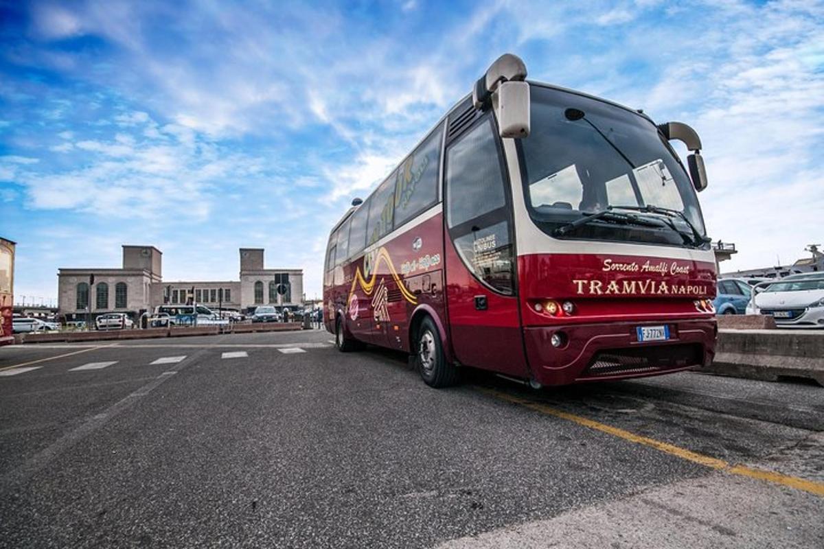 en rød buss er parkert på en parkeringsplass