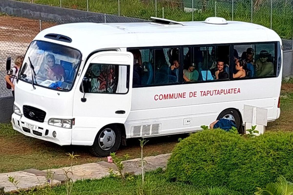 a white bus with people sitting inside of it