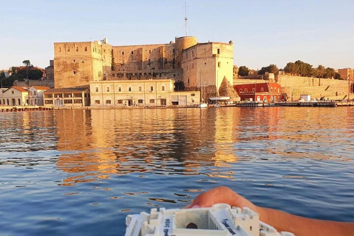 o persoană într-o barcă în apa din fața unui castel