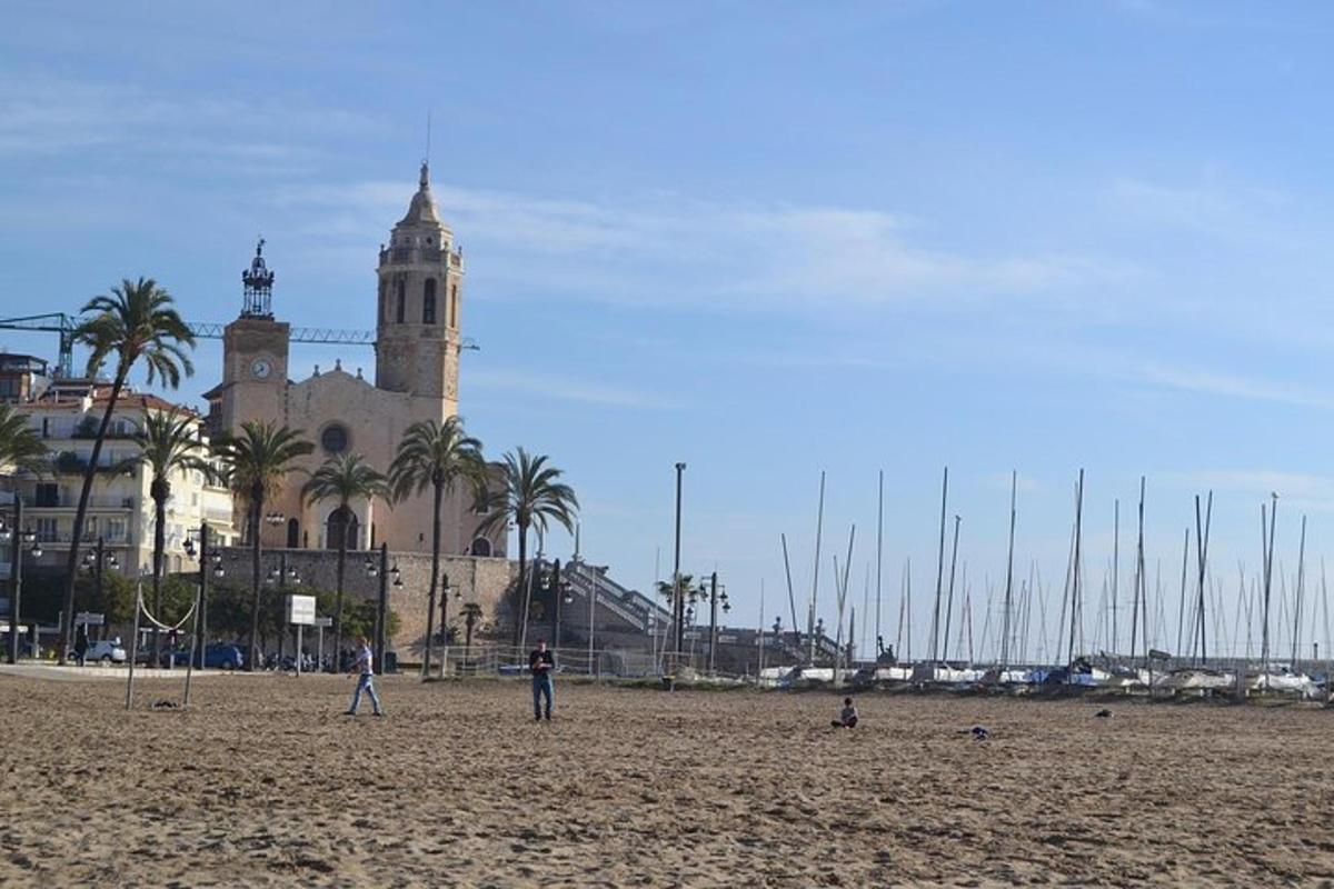 Gente de pie en una playa con un edificio al fondo