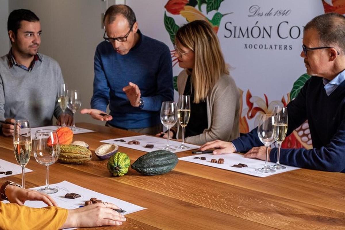 Un grupo de personas sentadas alrededor de una mesa con copas de vino.