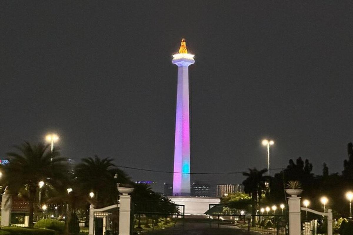 a tower lit up in pink and purple at night