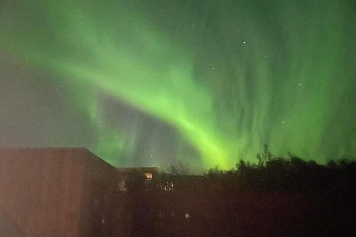 Norðurljós á himni yfir byggingu og byggingu