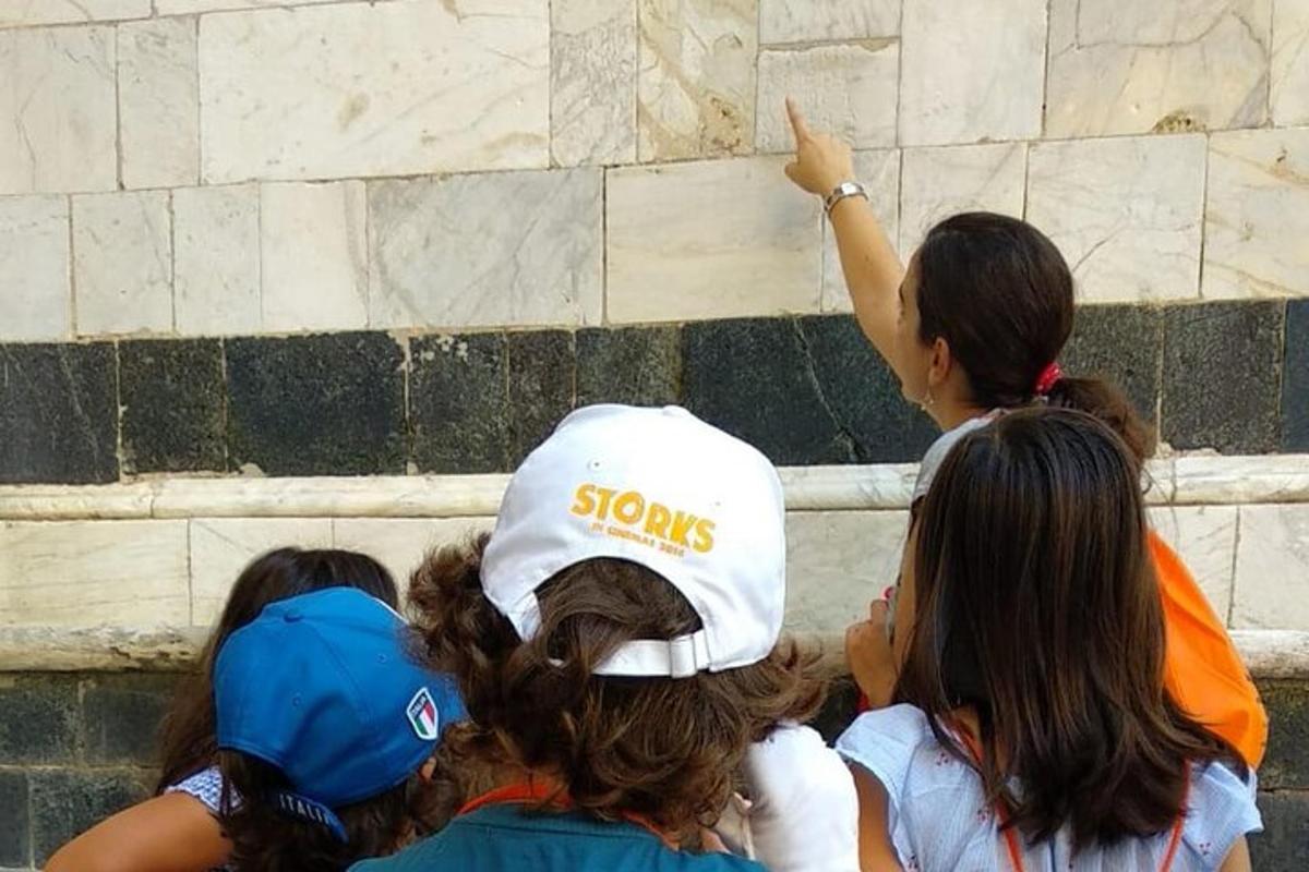 un grup de oameni care se uită la un zid de piatră