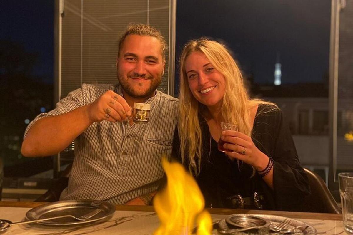 muž a žena sedící u stolu a držící brýle