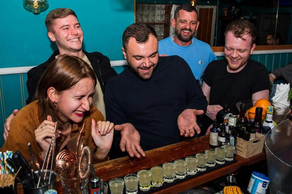 un gruppo di persone in piedi attorno a un bar con una donna
