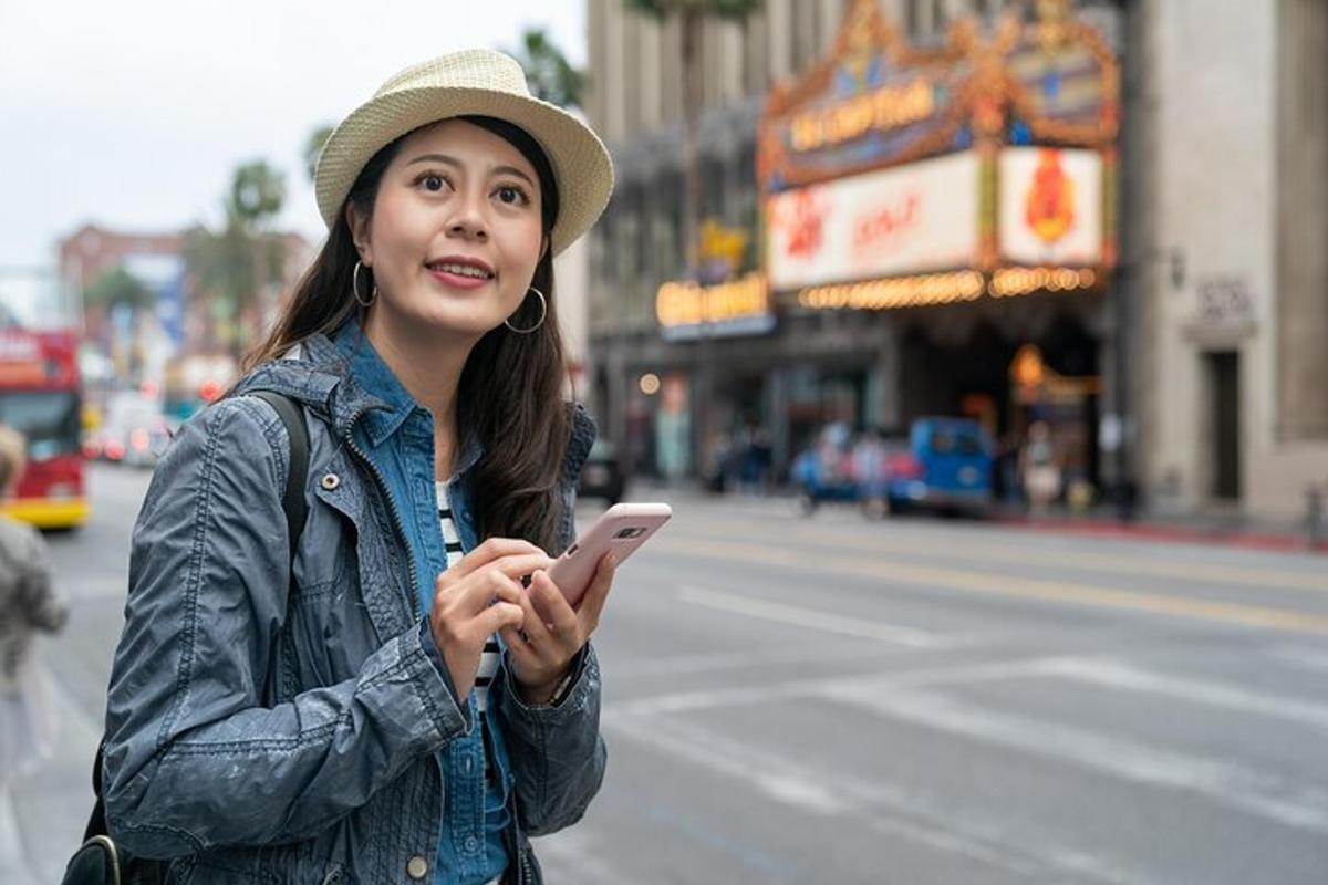 una donna con un cappello che guarda il suo cellulare