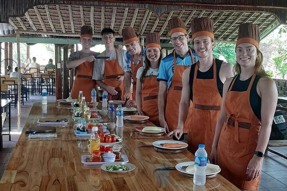 Un grupo de personas con delantales de pie alrededor de una mesa.