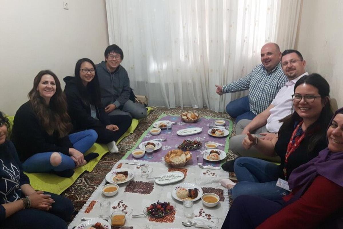 un grup de oameni așezați în jurul unei mese cu mâncare