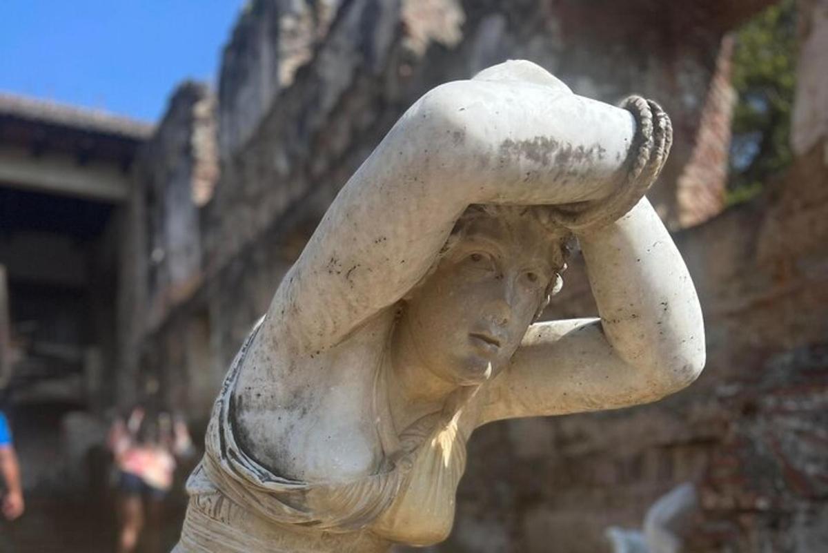 a statue of a woman holding a hat