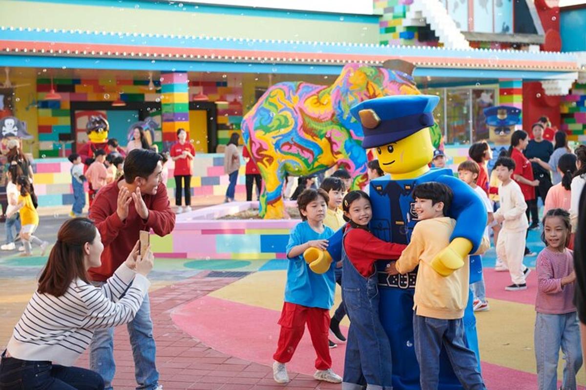 Un grupo de niños de pie frente a un parque infantil.