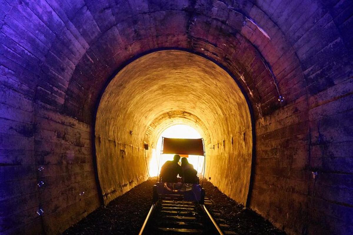 Dos personas sentadas en un banco en un túnel.