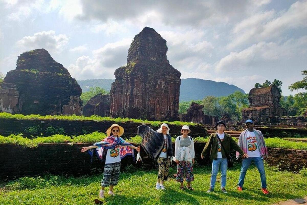 Un grupo de personas de pie frente a unas ruinas.