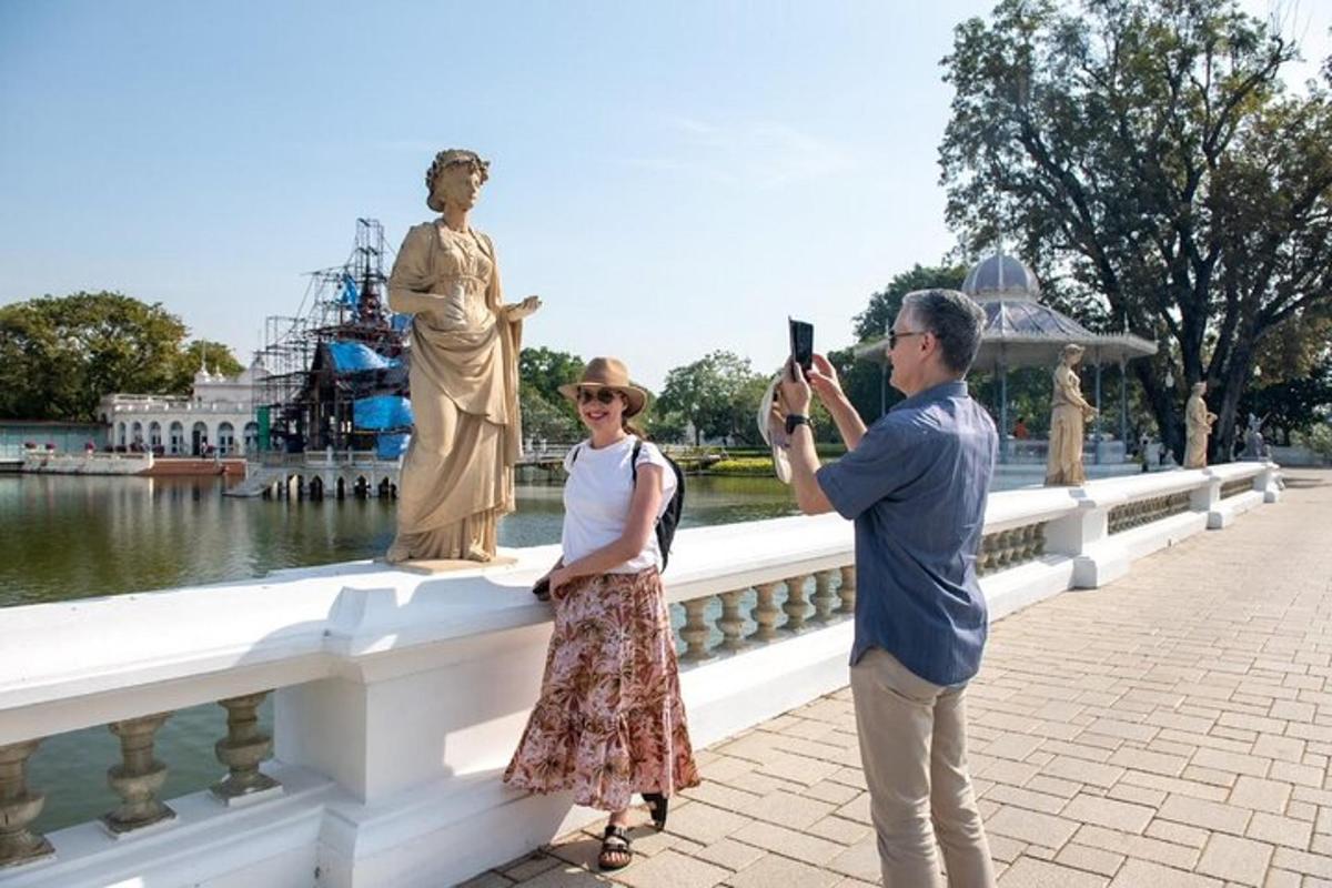 um homem tirando uma foto de uma mulher tirando uma foto de uma estátua