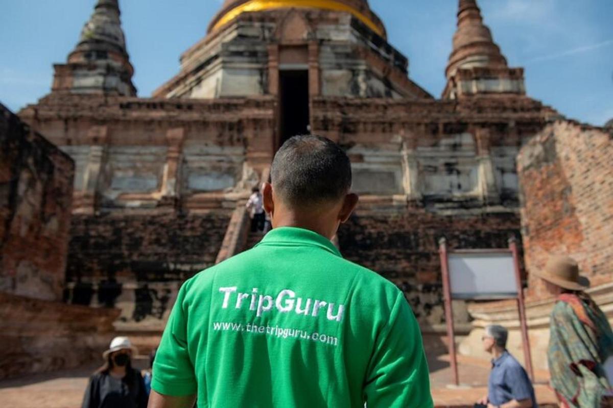 um homem de camisa verde parado em frente a um prédio