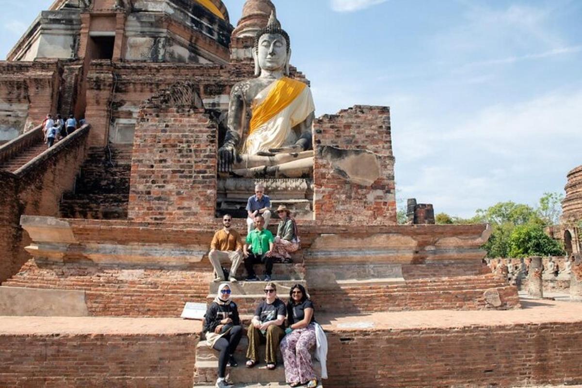 um grupo de pessoas sentadas em frente a uma estátua