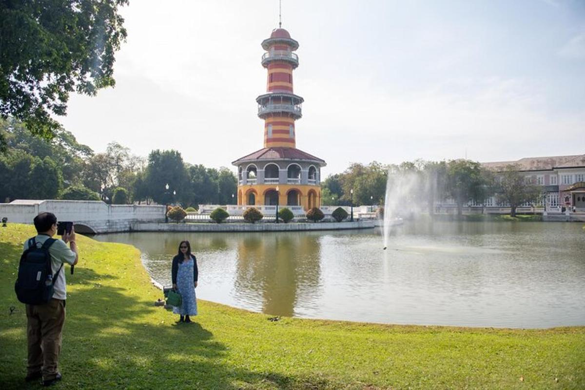 um homem e uma mulher tirando uma foto de uma torre em um lago