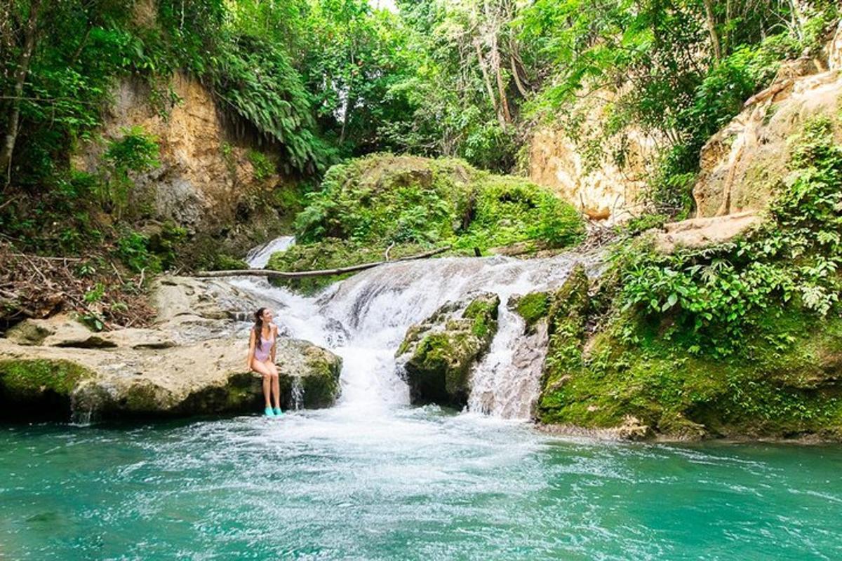 seorang wanita berdiri di dalam air di hadapan air terjun