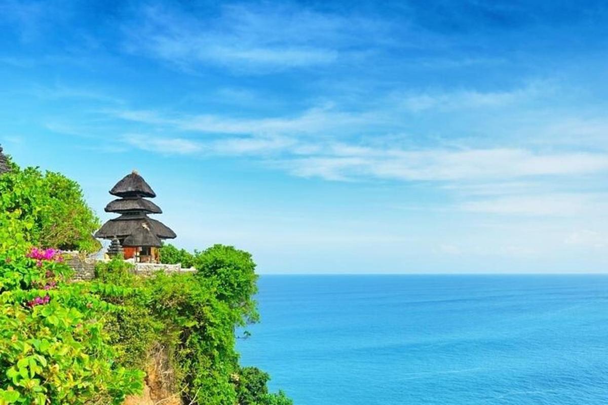 a small building on top of a hill next to the ocean