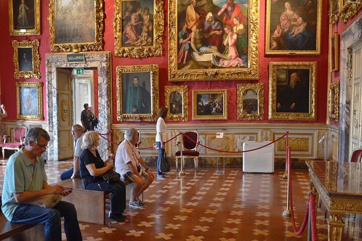 egy csoport ember ül egy szobában, amelynek falán festmények vannak