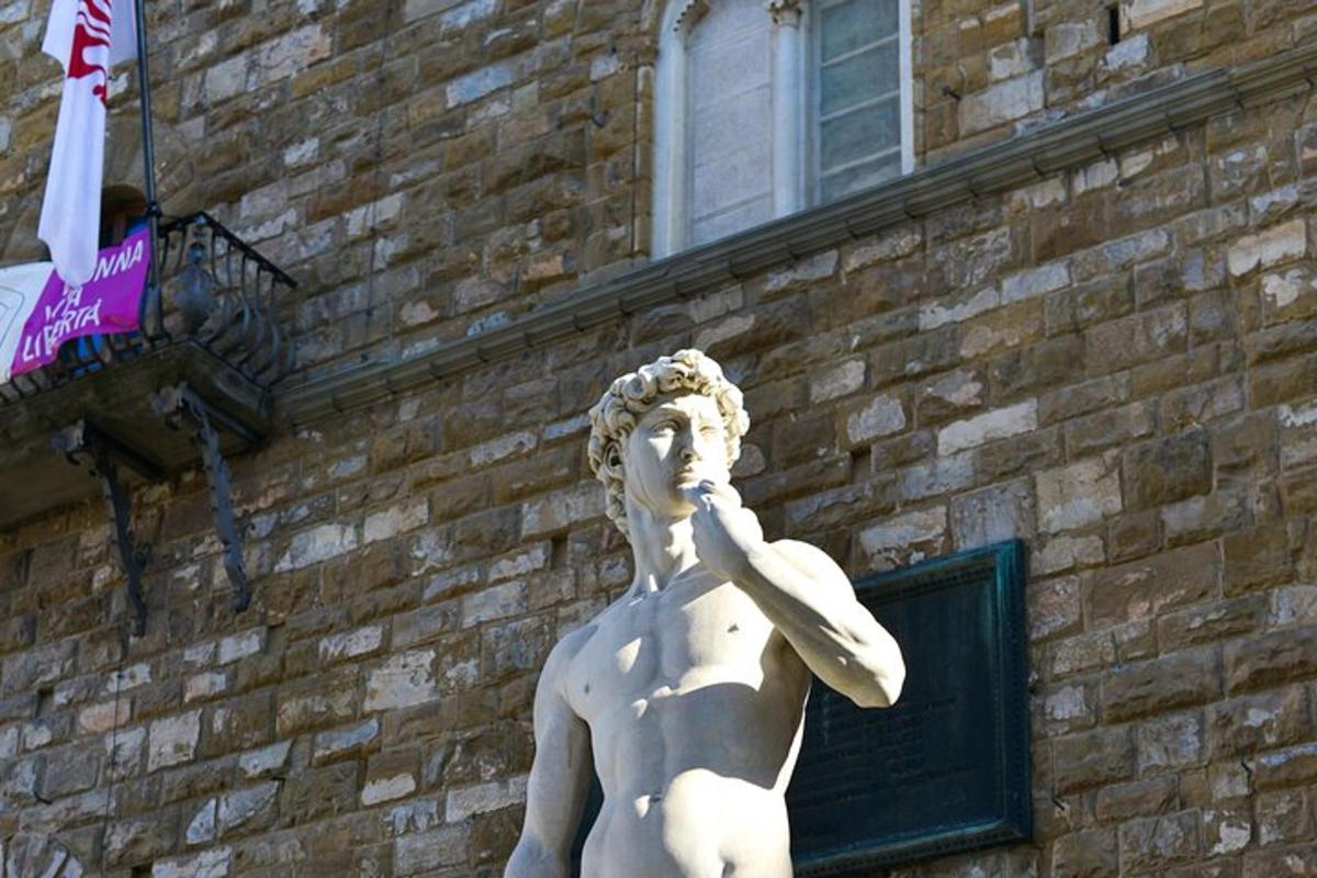 una statua di un uomo in piedi davanti a un edificio in mattoni