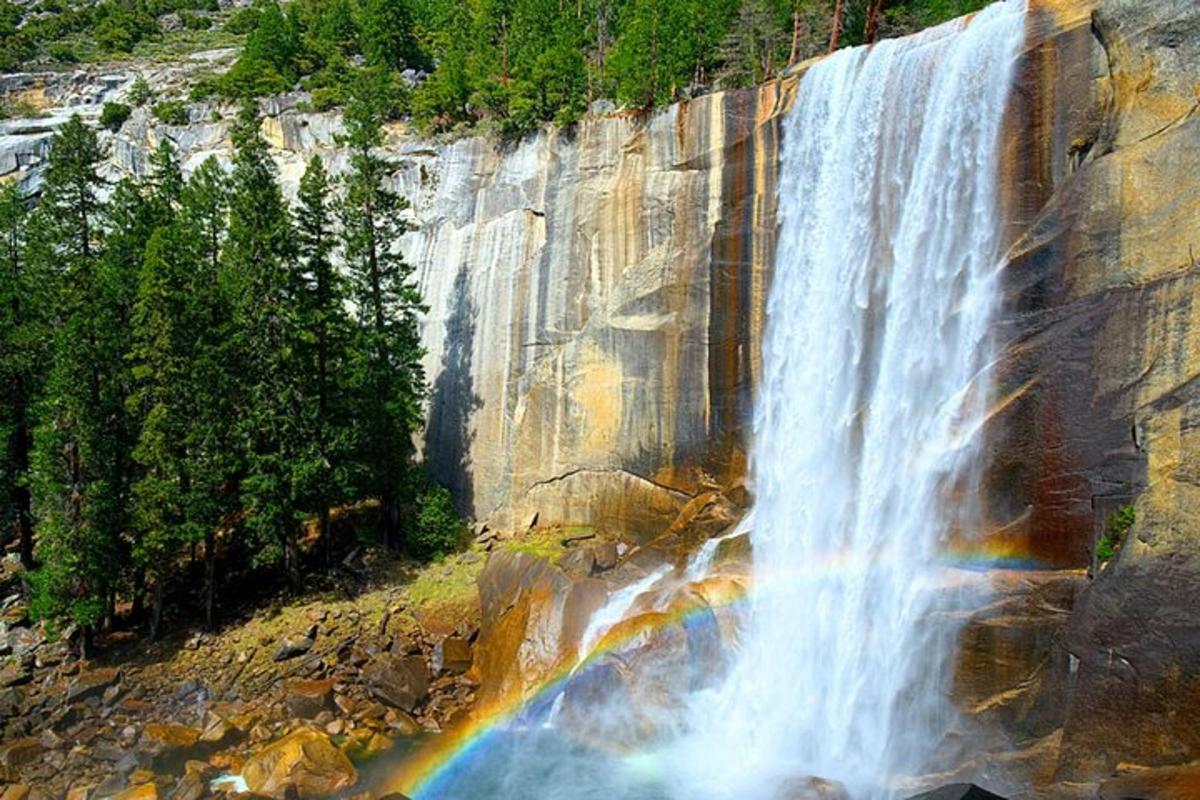 a waterfall with a rainbow on the side of a mountain