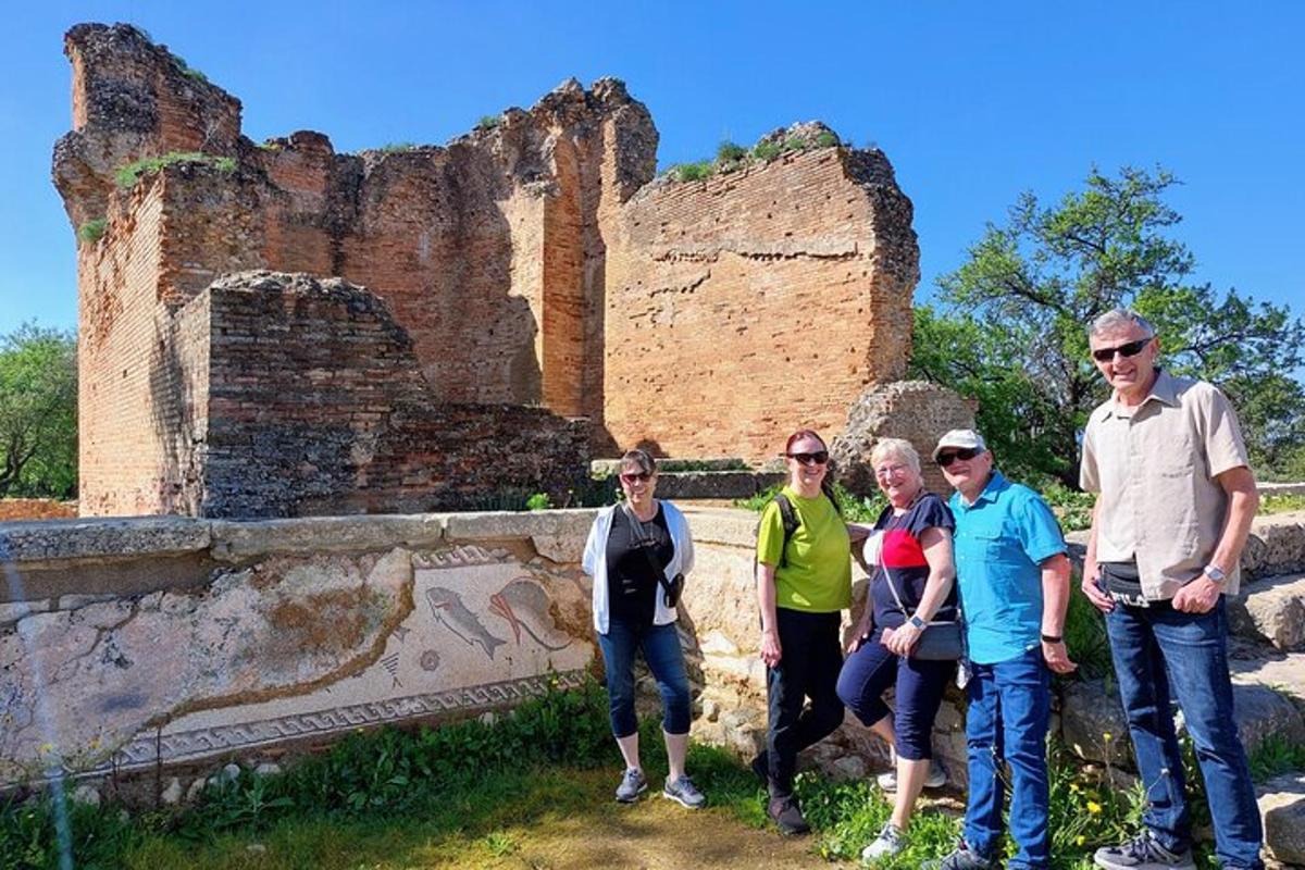 un gruppo di persone in piedi davanti a delle rovine