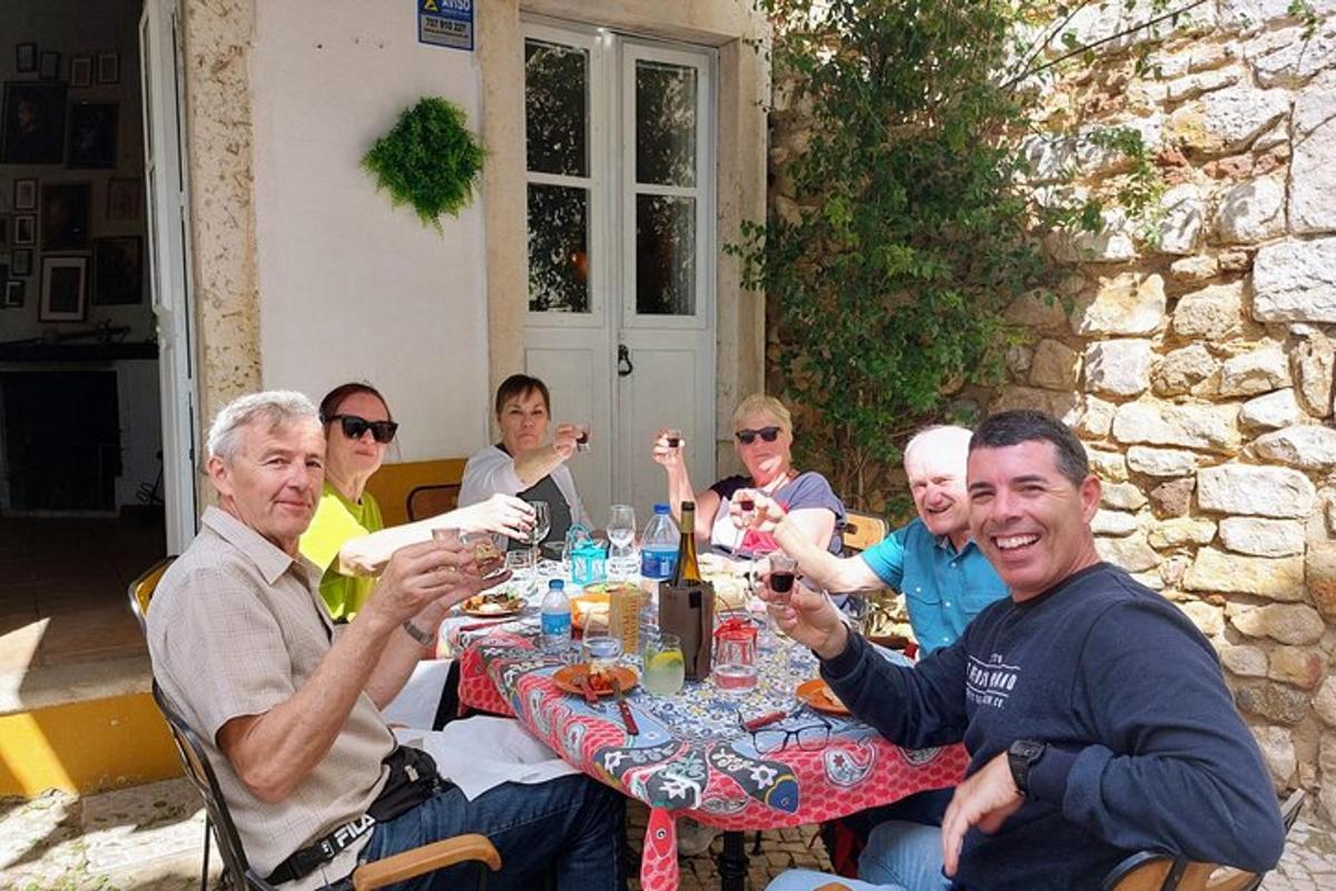 un gruppo di persone sedute a un tavolo che bevono vino