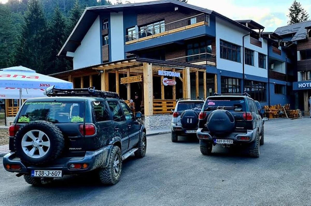 dois carros estacionados em um estacionamento em frente a um prédio