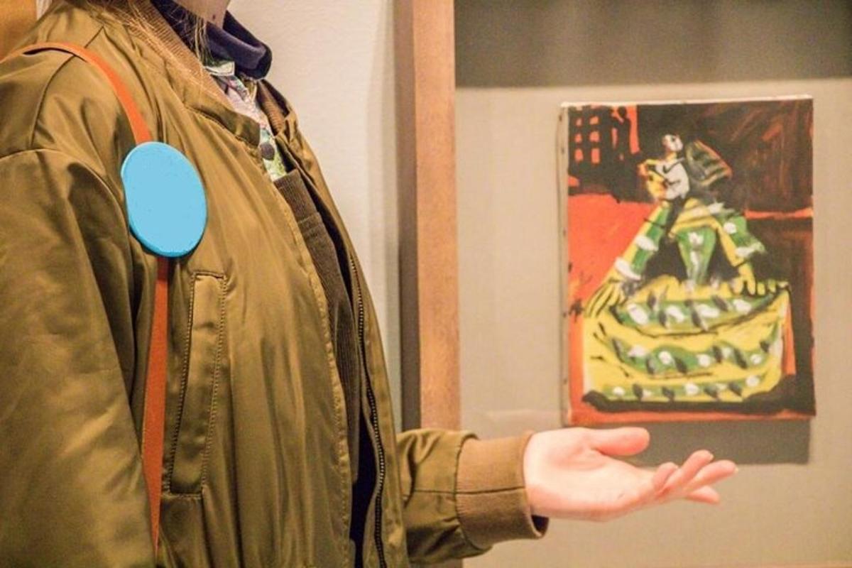 그림 앞에 손을 내밀고 있는 사람