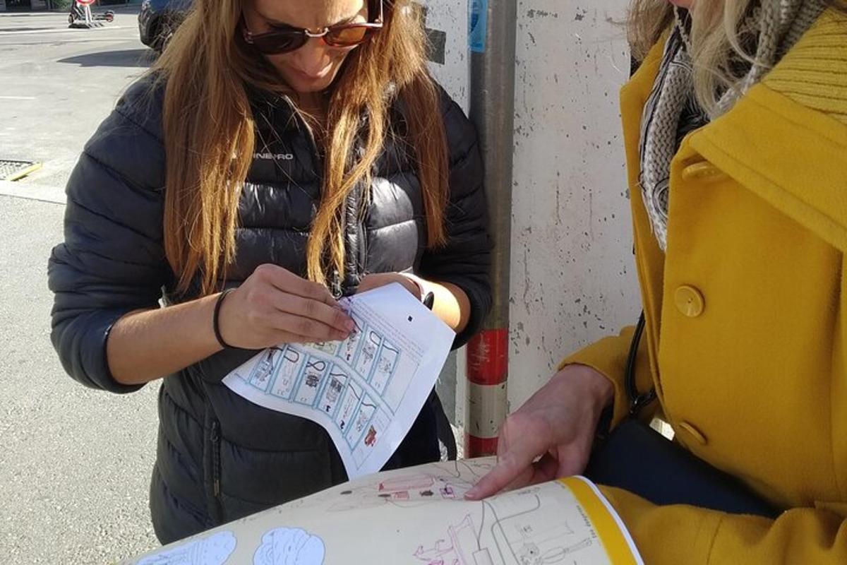 dalawang babae ang nakatingin sa isang drawing sa isang papel