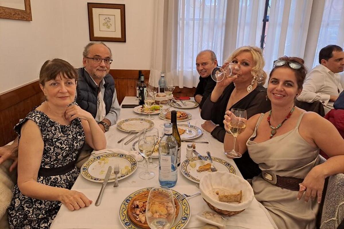 skupina lidí sedících u stolu s vinnými sklenicemi