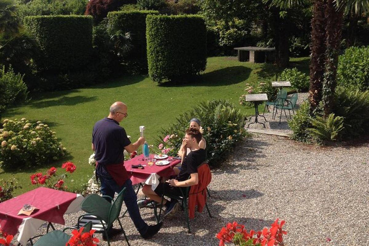 eine Gruppe von Menschen sitzt an einem Tisch in einem Garten