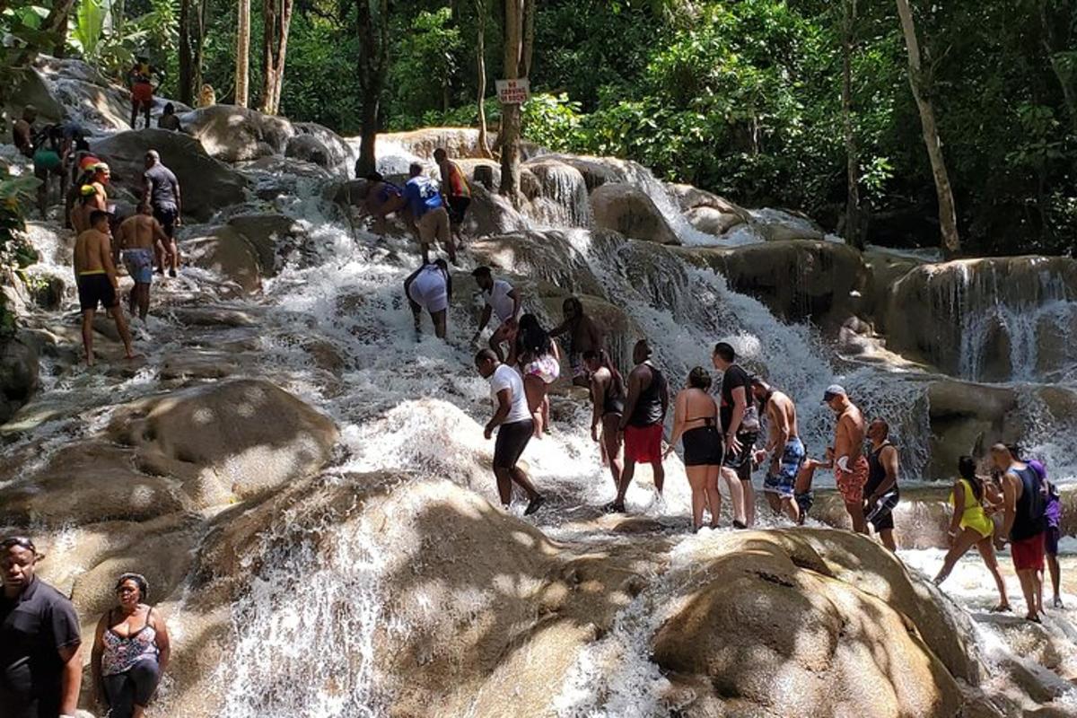 sekumpulan orang berdiri di atas batu di air terjun