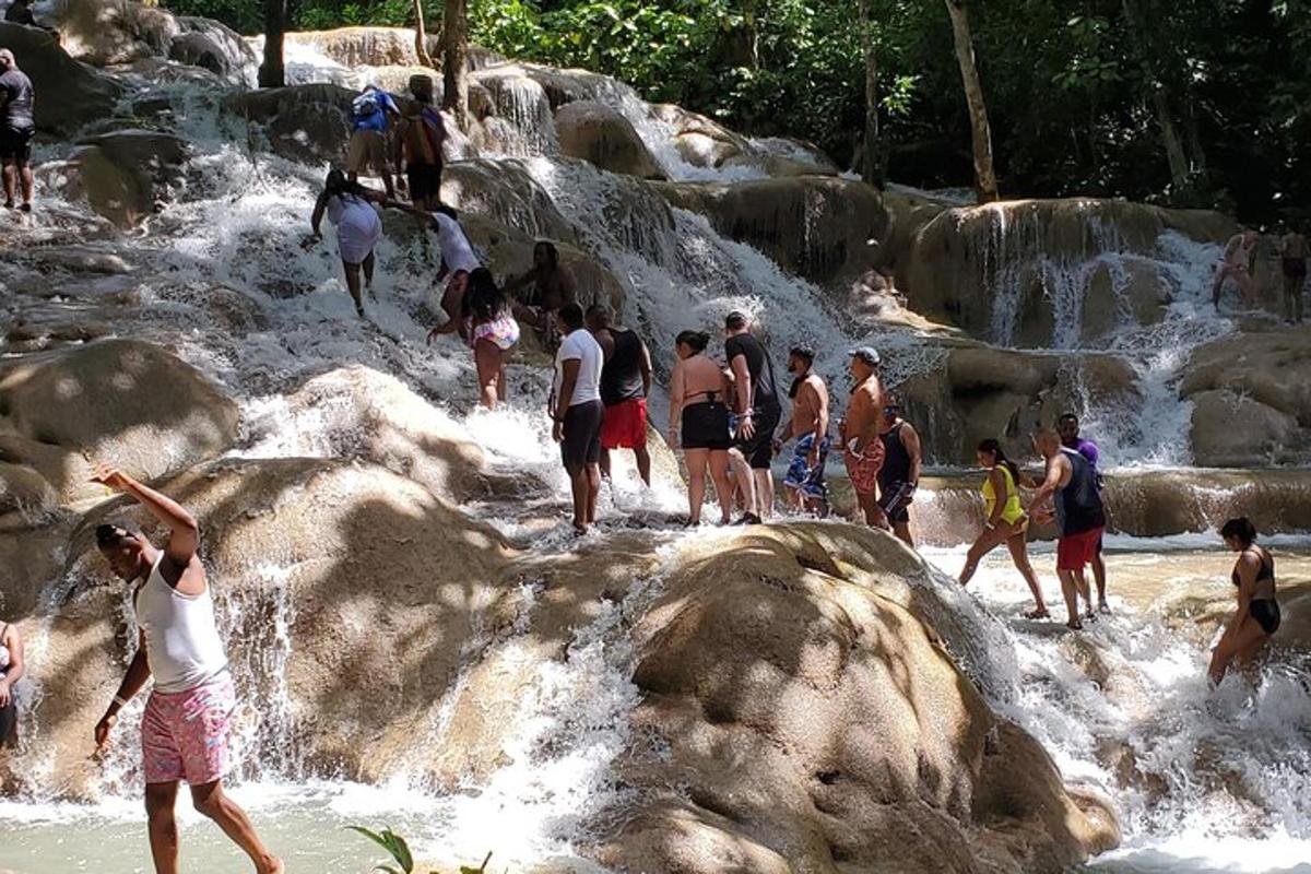 sekumpulan orang berdiri di dalam air di air terjun