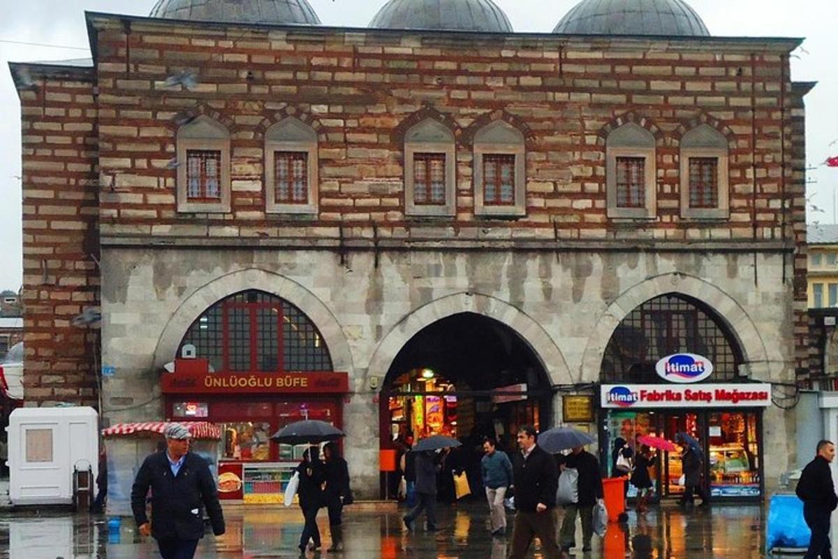skupina lidí kráčejících před budovou v dešti