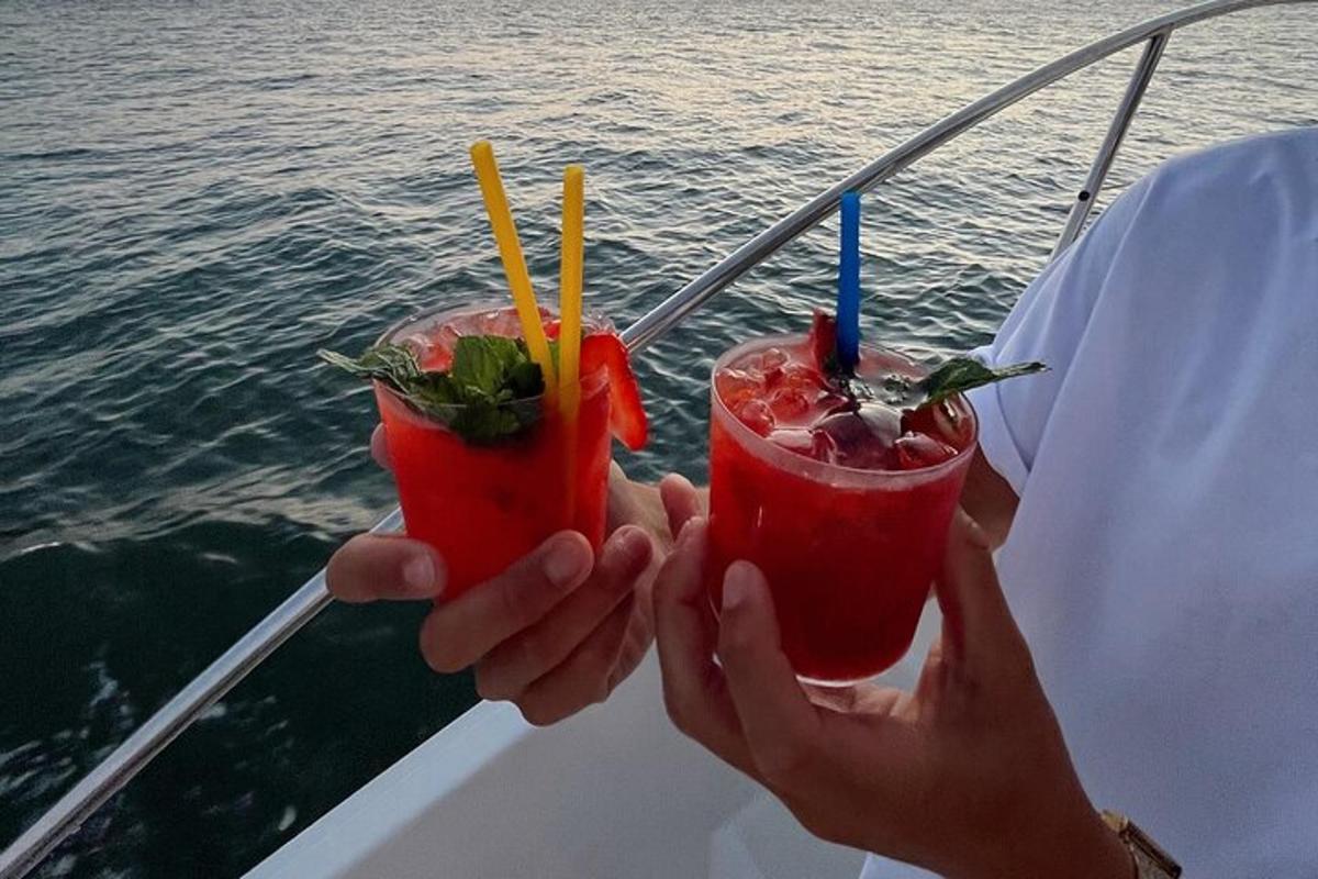 uma pessoa segurando dois coquetéis em um barco