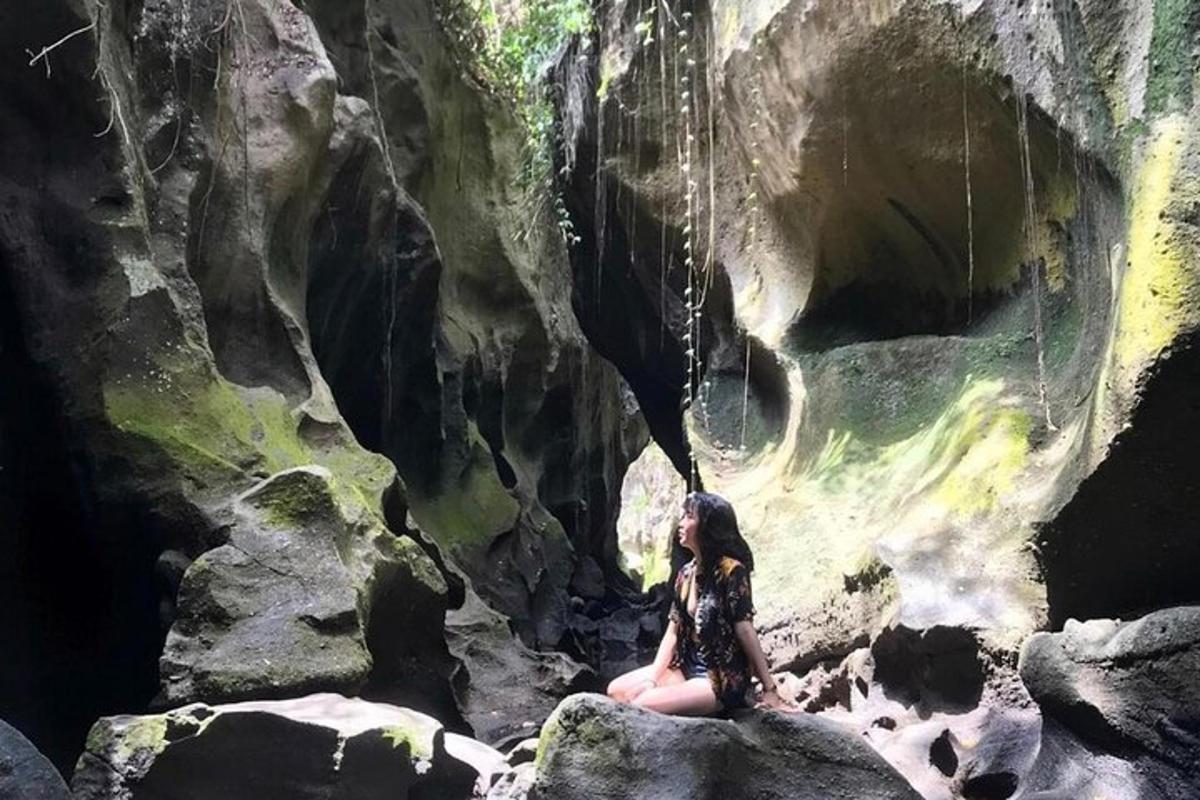 una mujer sentada en una roca en una cueva